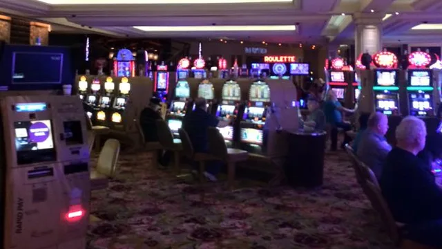 A row of lit slot machines on a casino floor